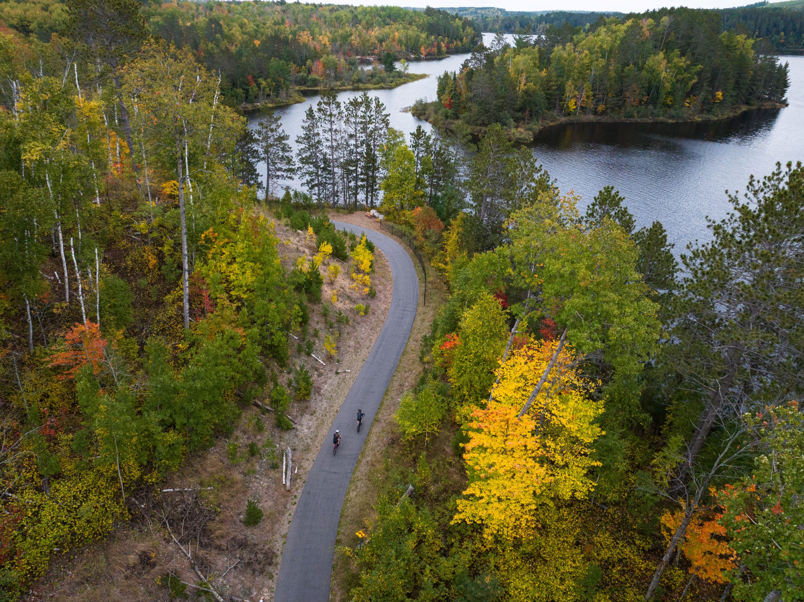 Cyclists on the Mesabi Trail through fall foliage on the Iron Range